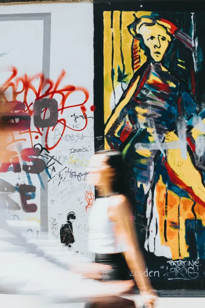A vibrant, detailed close-up of a street art mural showing layers of colorful spray paint.